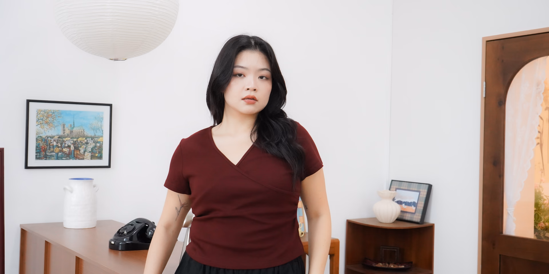 Model wearing a dark red wrap top from The Fleur Label