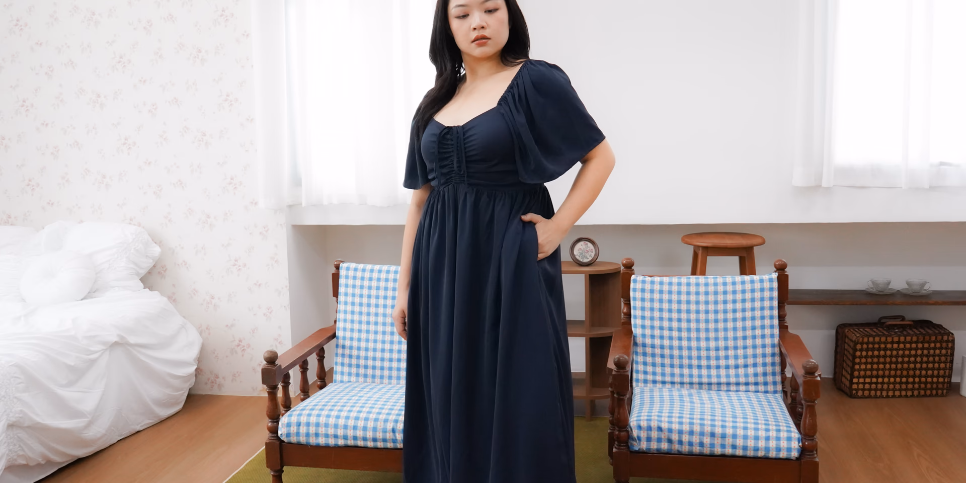 Model wearing a navy full-length dress from The Fleur Label